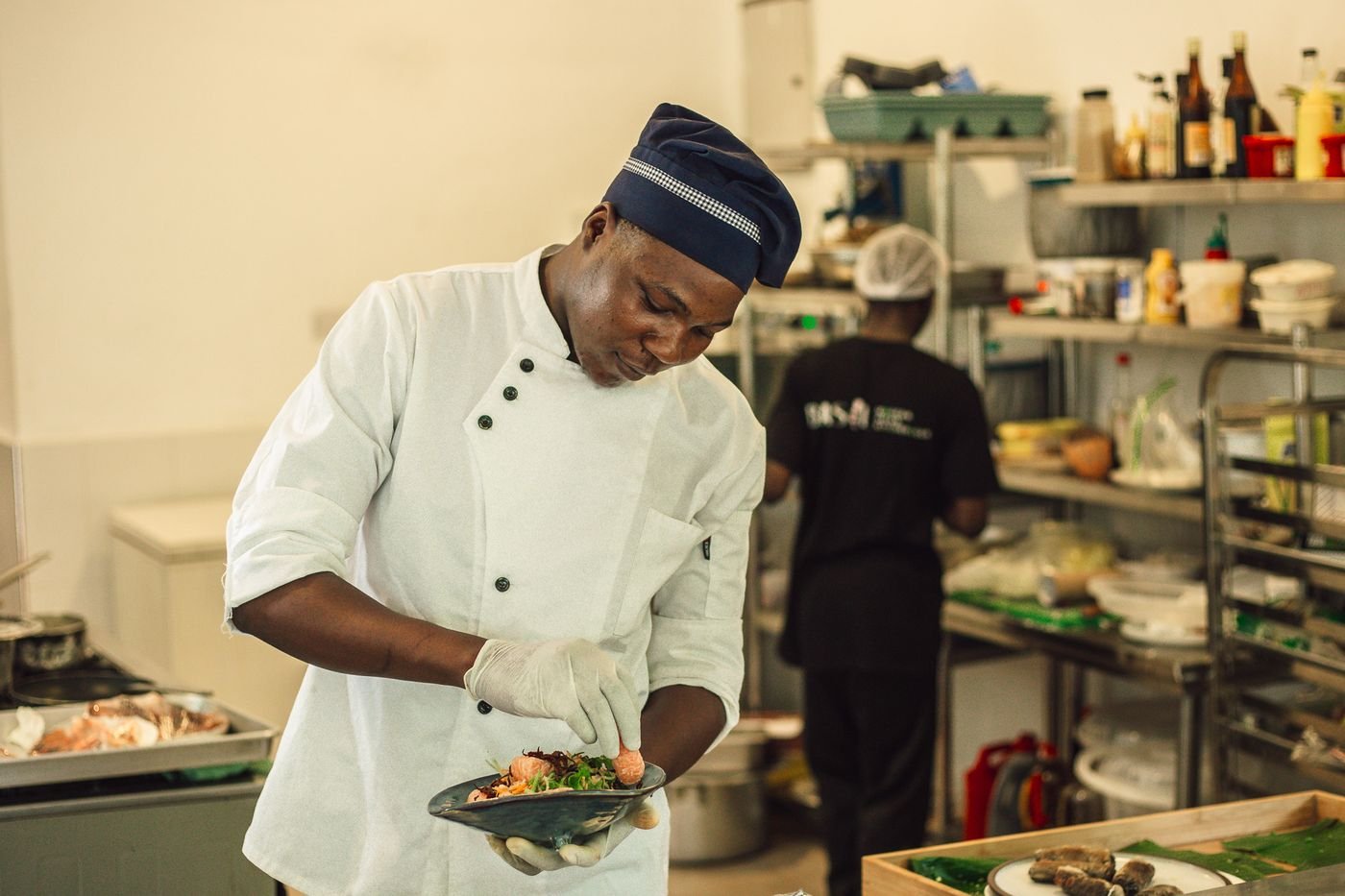 Basil head chef plating a modern Asian dish in the kitchen, Paje, Zanzibar